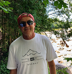 Headshot of Miki wearing a backwards, red hat and sunglasses in the outdoors